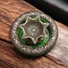 oxidized white metal diya on glass base placed on table top