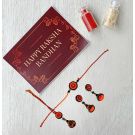 paper quiling bhaiya bhabhi rakhi set with earrings combo placed with rakshabandhan card and roli chawal bottles