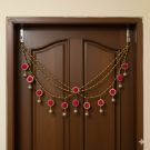 golden beads and pink pompom toran hanging on door