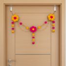 yellow - pink pompom toran hanging on cream colored door