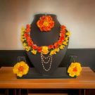 orange - yellow flowers jewellery for haldi on mannequin