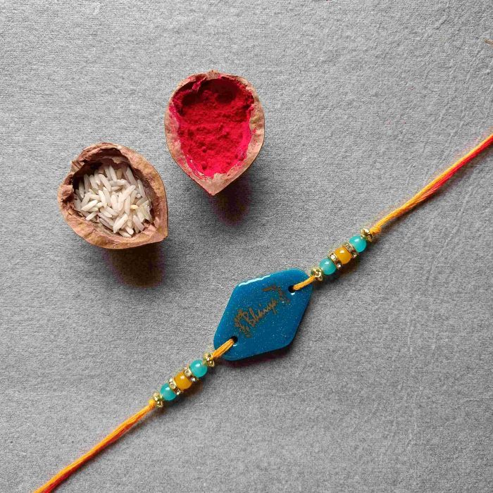 blue 'pyara bhaiya' resin rakhi placed with roli akshat combo