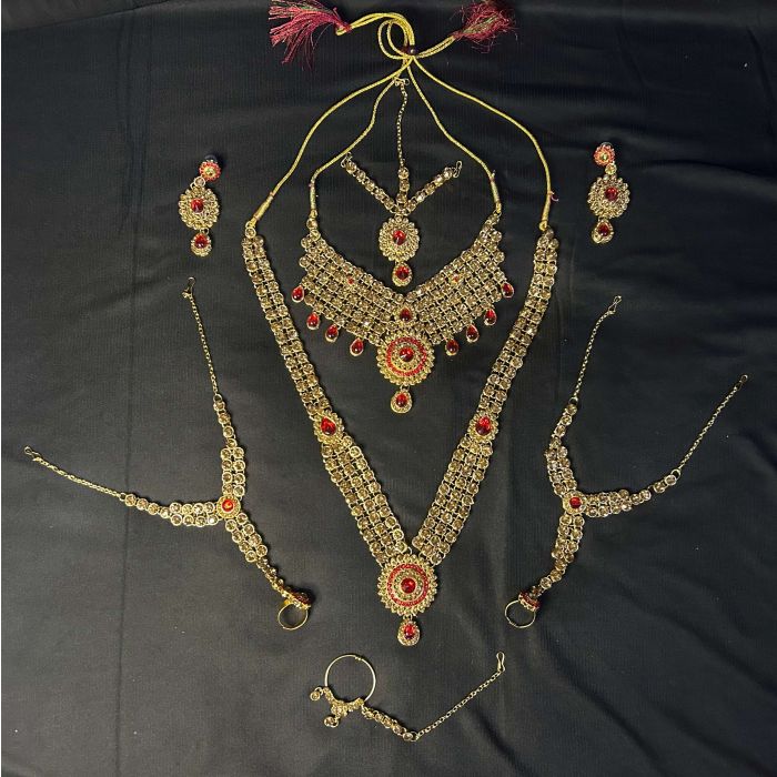 golden brown and red stone work bridal jewellery set for wedding - placed on black background