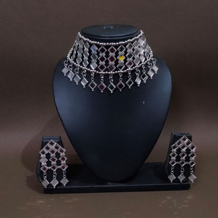 silver mirror jewellery set in mannequin on brown background