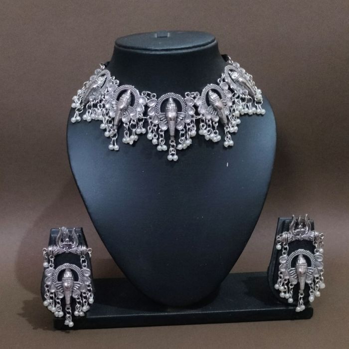 silver ganesha necklace set in mannequin on brown background