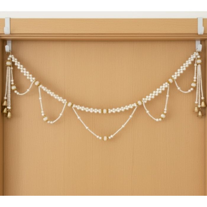 knotted pearl toran hanging on light wooden door 