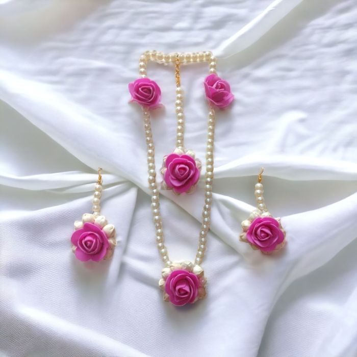 mogra flower jewellery set - pink color placed on white fabric background