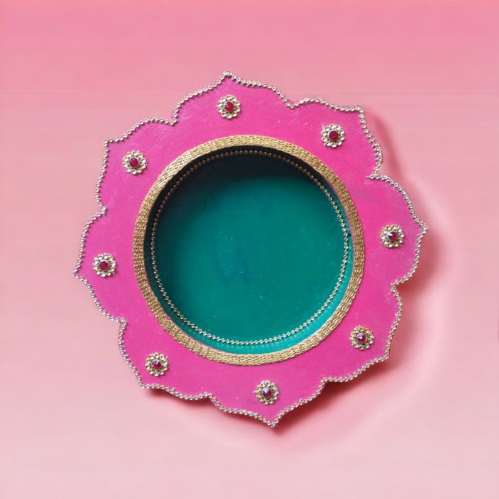 pink-green decorative pooja thali placed on pink countertop
