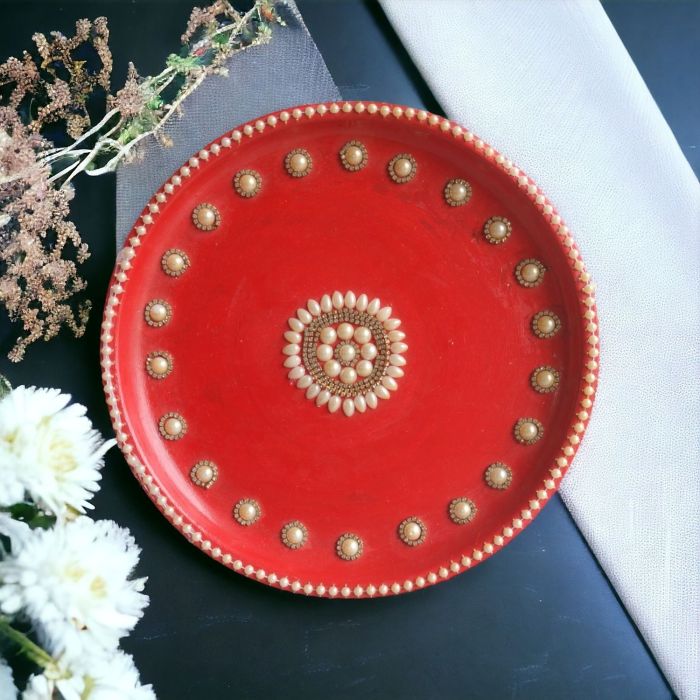 decorative pooja thali in red color placed on white and black table top