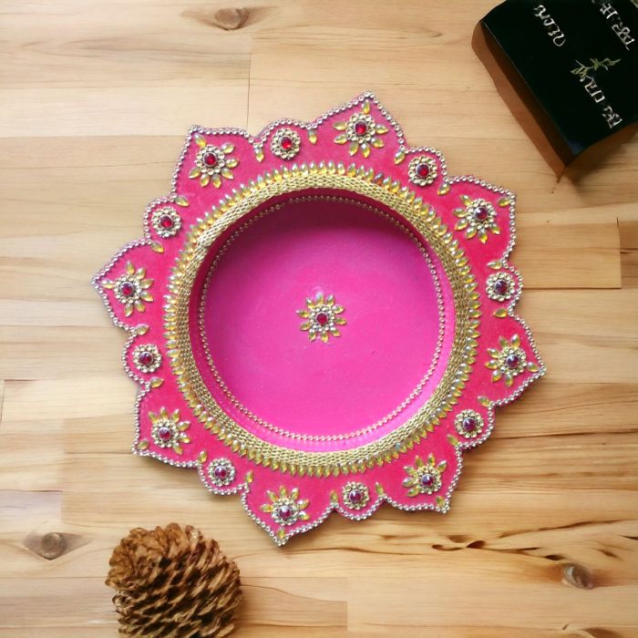 decorative pooja thali in red color placed on tabletop