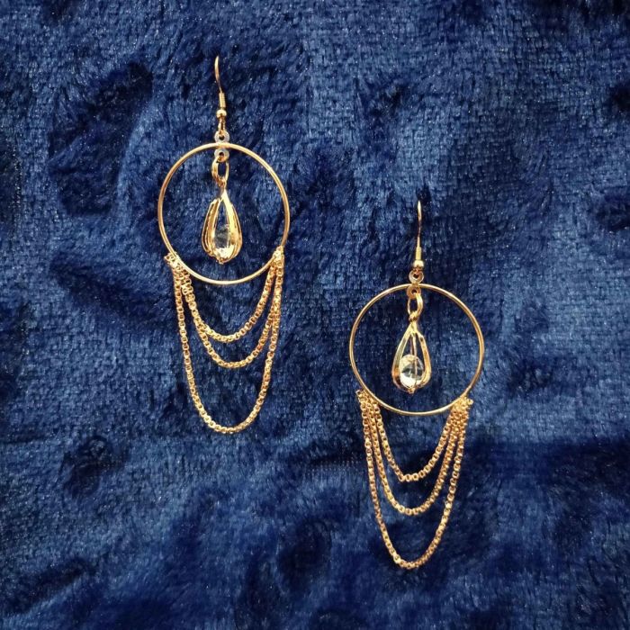 rose gold hoop earrings with chain fringe placed on blue velvet fabric