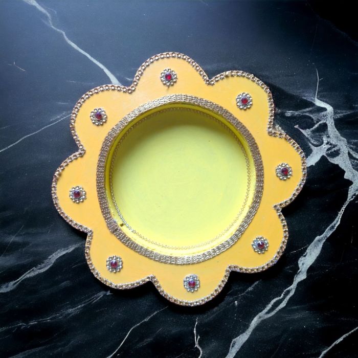 yellow pooja thali on black marble countertop