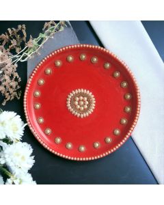 decorative pooja thali in red color placed on white and black table top