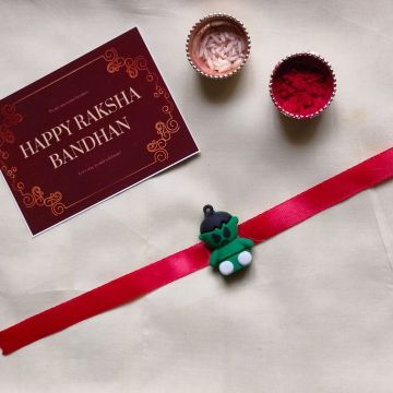 3D hulk son silcon rakhi cum keychain placed with roli chawal pack and rakshabandhan card 