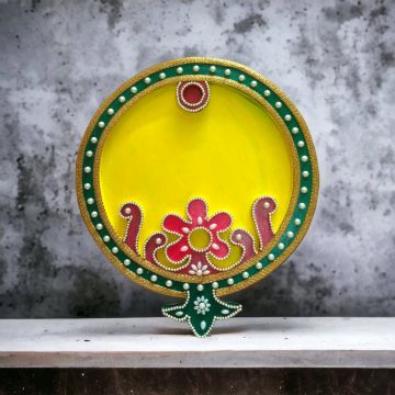 yellow decorative wooden thali for pooja on table top