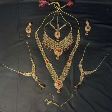 golden brown and red stone work bridal jewellery set for wedding - placed on black background