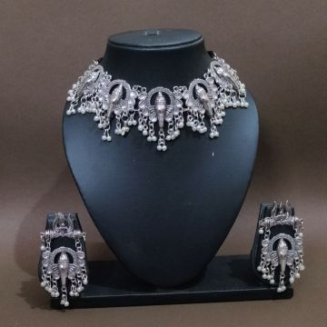 silver ganesha necklace set in mannequin on brown background