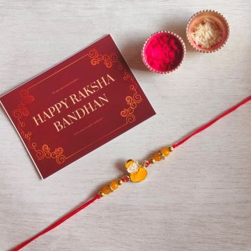 little kid cartoon rakhi with roli chawal and rakshabandhan card 