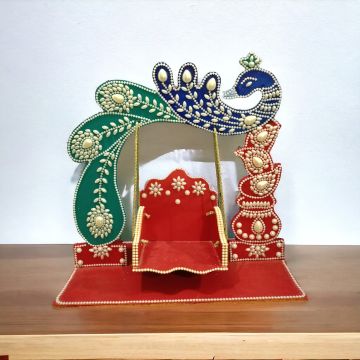 peacock laddu gopal jhula placed on tabletop
