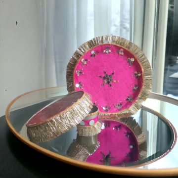karwa chauth thali set pink colour decorated with mirror work placed on mirror table