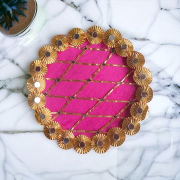 pink gota and mirror work stainless steel decorative pooja thali placed on marble countertop - top view