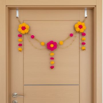 yellow - pink pompom toran hanging on cream colored door