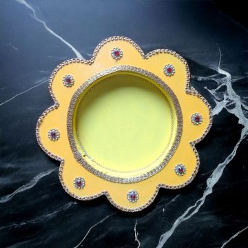 yellow pooja thali on black marble countertop